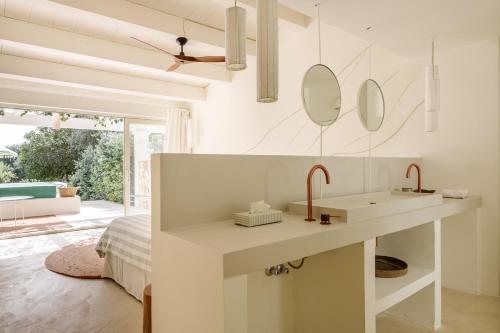 a white bathroom with a sink and mirrors at Morvedra Nou Luxury Boutique Hotel - Adults Only in Ciutadella