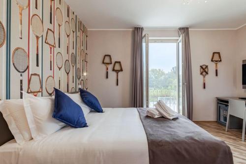 una camera da letto con un grande letto bianco con cuscini blu di L'aja della Mirusina - Piedmont Resort Monferrato Langhe a Canelli