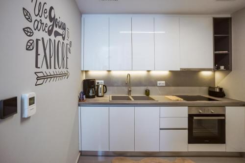 a kitchen with white cabinets and a sink at Urban Apartments in Chios