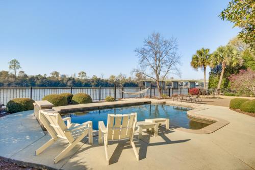 a swimming pool with two chairs and a table and a table and chairsitures at Riverfront North Augusta Home with Private Pool! in North Augusta