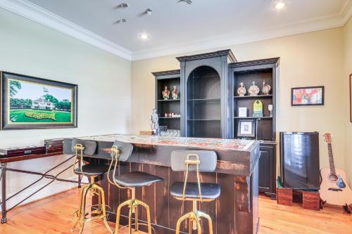 a bar with stools in a room with a guitar at Riverfront North Augusta Home with Private Pool! in North Augusta
