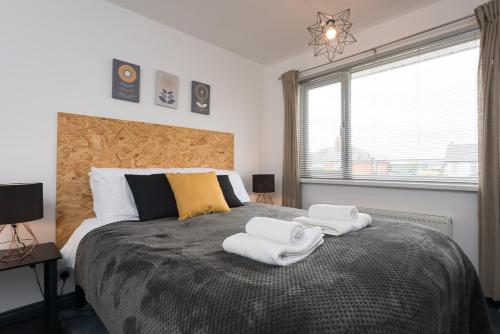 a bedroom with a large bed with towels on it at Superb Beverley 3 Bedroom House with Private Parking and Garden - The Nicholson in Beverley