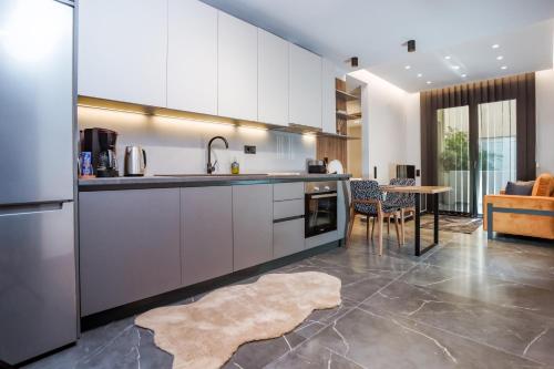 a kitchen with white cabinets and a table at Urban Apartments in Chios