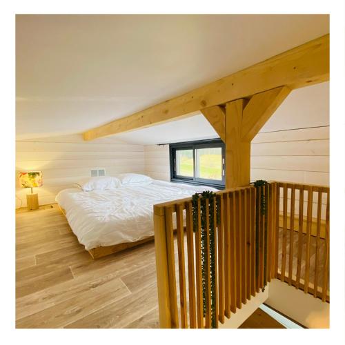 - une chambre avec un lit et un escalier en bois dans l'établissement Tiny house Kapha, à Les Alliés