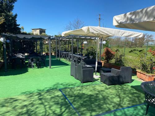 a patio with a table and chairs on green grass at Hotel Motel Visconteo in Binasco