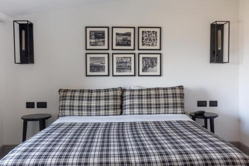 a bedroom with a bed with four pictures on the wall at Maison Bon Bon in Sorrento