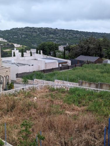 a building on top of a hill with a field at bali carmel zimmer & spa in Dāliyat el Karmil