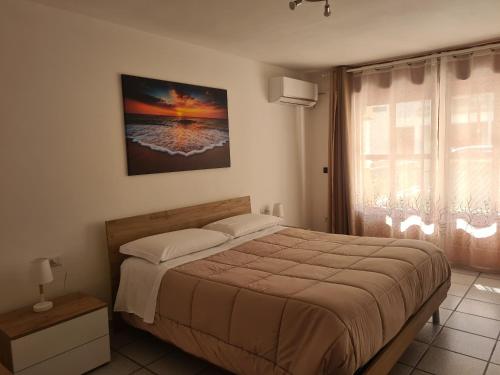 um quarto com uma cama grande e uma janela em Venere Home em Metaponto