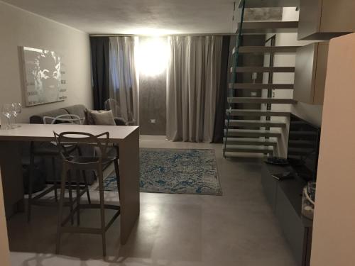 a living room with a staircase and a table and chairs at L'Angolino Nascosto in Verona