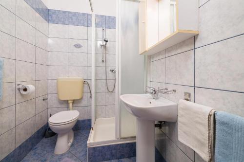 a bathroom with a toilet and a sink and a shower at Apartment Julija in Povile