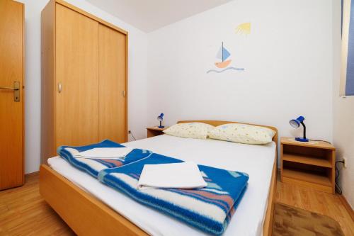 a bedroom with a bed with blue towels on it at Apartment Julija in Povile