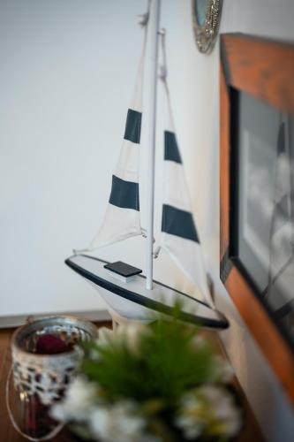 a toy boat sitting on a table with flowers at Haus der Geschenke - Carinthia in Velden am Wörthersee