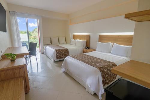 um quarto de hotel com duas camas e uma televisão em GHL Hotel Club el Puente em Girardot