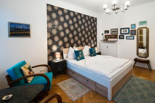 a bedroom with a bed and a chair and a mirror at Haus der Geschenke - Carinthia in Velden am Wörthersee