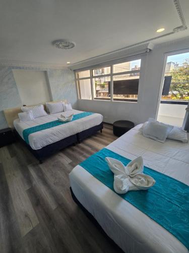 a bedroom with two beds and a window at Hotel Zafiro Boutique in Bogotá