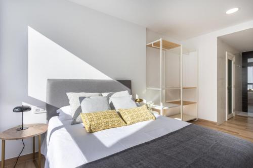 Un dormitorio con una cama blanca con dos almohadas amarillas. en Sunnyland atico cruz, en San Andrés