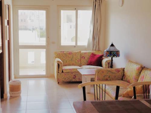 Sunny, Modern 2 bed in Makadi Heights, Hurghada في سفاجا: غرفة معيشة مع أريكة وطاولة