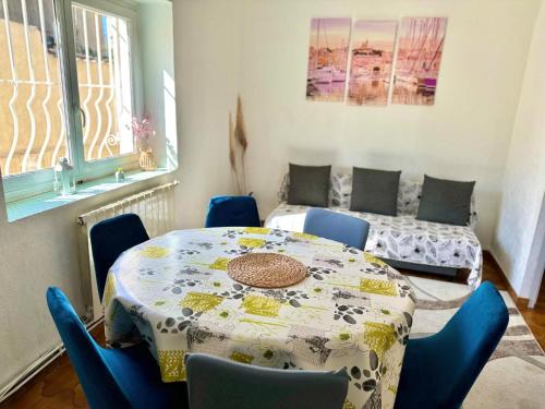 une salle à manger avec une table et des chaises et une fenêtre dans l'établissement Maison Confort & Silence, Jardin & Barbecue, à Marseille