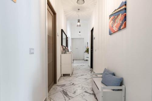 ナポリにあるColori e Noteの白い壁の廊下、椅子が備わる客室です。