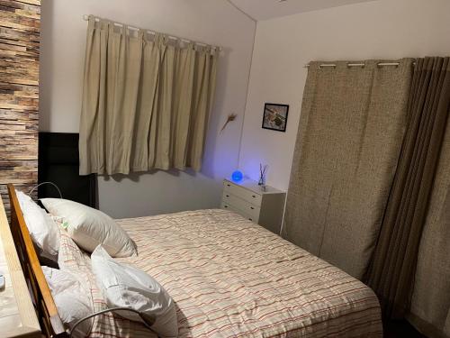 um quarto com uma cama e uma cómoda e cortinas em Dépendance villa em Peynier