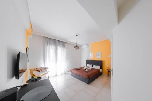 1 dormitorio con 1 cama y TV en una habitación en Orsiida Family apartment Volos en Volos