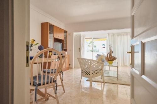 a kitchen and dining room with a table and chairs at Lovely Apartment in San Agustín: Steps Away from Playa Del Inglés and Maspalomas! in San Bartolomé de Tirajana