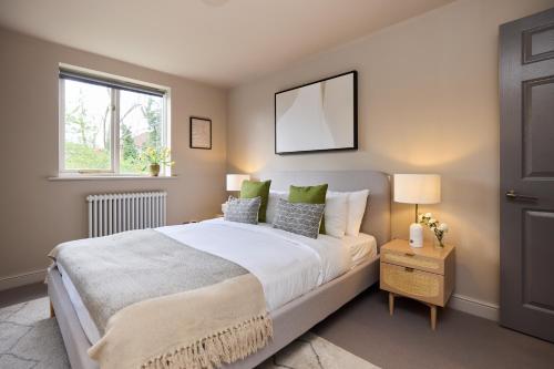 a bedroom with a large bed and a window at The Twickenham Wonder - Lovely 1BDR Flat with Parking in Twickenham