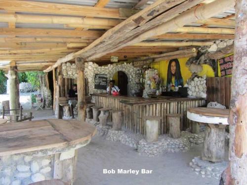 an outdoor bar in a wooden building with wooden ceilings at Real Jamaica - Cabin right beside the sea-Papa Curvins Yard in Oracabessa
