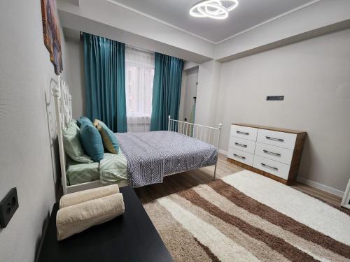 a small bedroom with a bed and a dresser at Diamond Apartment in Osh