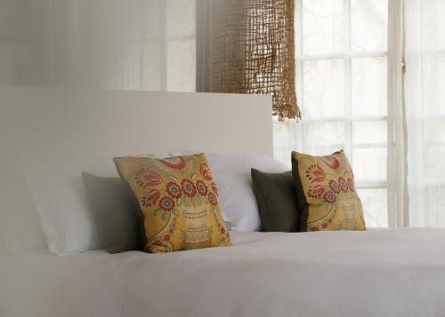 - un lit blanc avec deux oreillers et une fenêtre dans l'établissement L'Abbaye Hôtel, à La Colle-sur-Loup