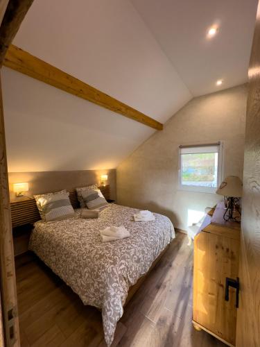 une chambre avec un lit et une fenêtre dans l'établissement gite L'Ecrin, à Saint-Paul-sur-Yenne