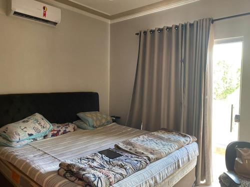 uma cama num quarto com uma janela em Casa com piscina disponível pra festa do peão em Barretos