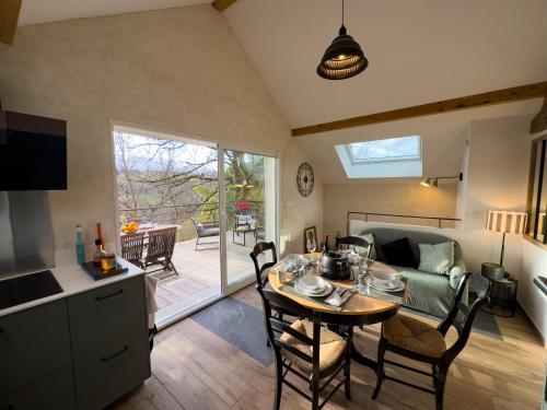 une cuisine et un salon avec une table et un canapé dans l'établissement gite L'Ecrin, à Saint-Paul-sur-Yenne