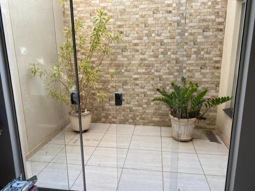 um quarto com dois vasos de plantas num piso de azulejo em Casa com piscina disponível pra festa do peão em Barretos