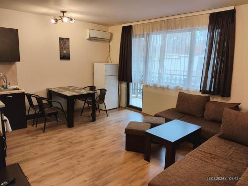 ein Wohnzimmer mit einem Sofa und einem Tisch in der Unterkunft Апартамент Езерото in Trjawna