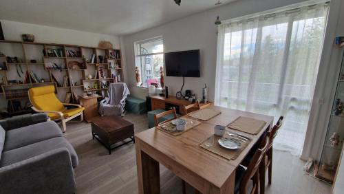 un salon avec une table en bois et un canapé dans l'établissement Chez Bambou, à Vaires-sur-Marne