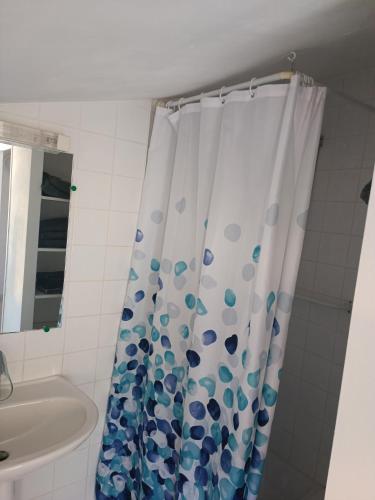 une salle de bain avec un rideau de douche et un lavabo dans l'établissement Camping les Lavandes, Castellane, à Castellane