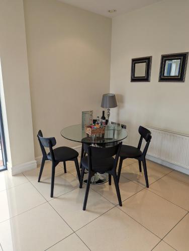 a dining room with a glass table and chairs at The Western Citypoint Apartments in Galway