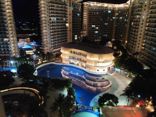 ein Gebäude mit Pool in einer Stadt in der Nacht in der Unterkunft Azure Urban Resort - By Ground Zero One in Manila