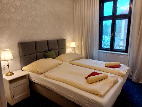 a bedroom with two beds with pillows and a window at Hotel Jeleň in Pezinok