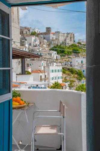 a chair on a balcony with a view of a city at FICO D'INDIA in Peschici