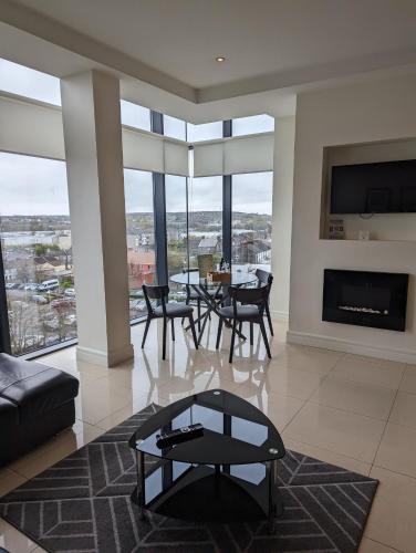 a living room with a table and chairs and a fireplace at The Western Citypoint Apartments in Galway