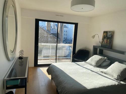a bedroom with a bed and a large window at Luxury appartment 10 mn from Champs-Elysées in Neuilly-sur-Seine