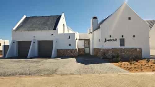 a white barn with two garage doors on it at Magical Mongoose in Jacobs Bay