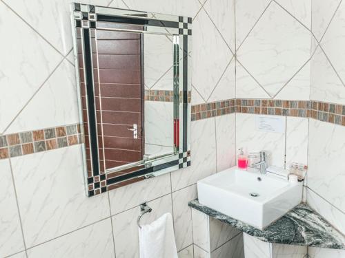 a bathroom with a sink and a mirror at Khutso Boutique Hotel in Hazyview