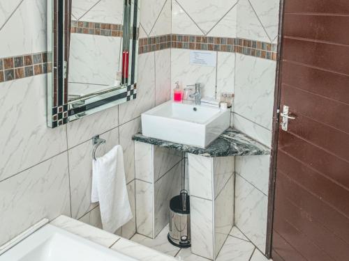 a bathroom with a sink and a mirror at Khutso Boutique Hotel in Hazyview