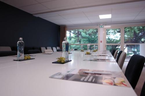 a conference room with a long table with bottles and chairs at Brit Hotel Marseille Aéroport - A&S in Les-Pennes-Mirabeau