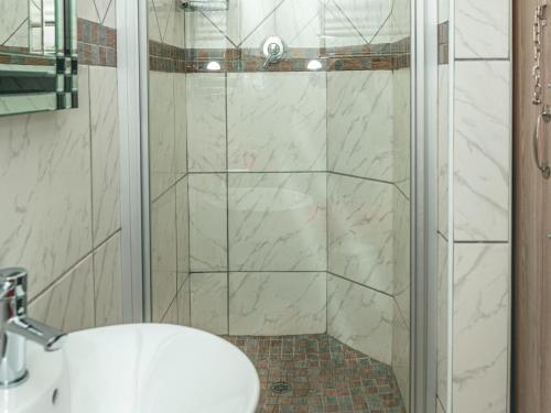 a bathroom with a shower with a sink and a toilet at Khutso Boutique Hotel in Hazyview