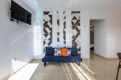 un soggiorno con divano blu e TV di EDMA APARTAHOTEL a Santa Bárbara de Samaná
