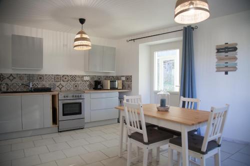 - une cuisine avec une table et des chaises en bois dans l'établissement Gîte Le Tilleul - Calme et lumineux - 2 à 4 pers, à Bessèges